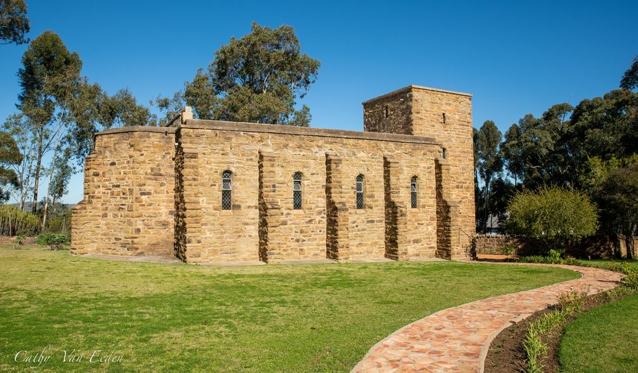 Exterior view of the Mary Myrtle Riggs Memorial Church in Bonnievale, featuring a stone structure with a path leading to it, surrounded by greenery.