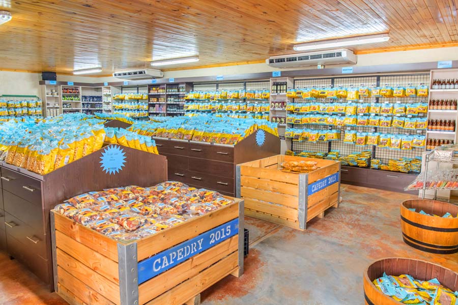 Interior view of Capedry Montagu Farmstall, showcasing displays of dried fruit products in wooden crates and bags.