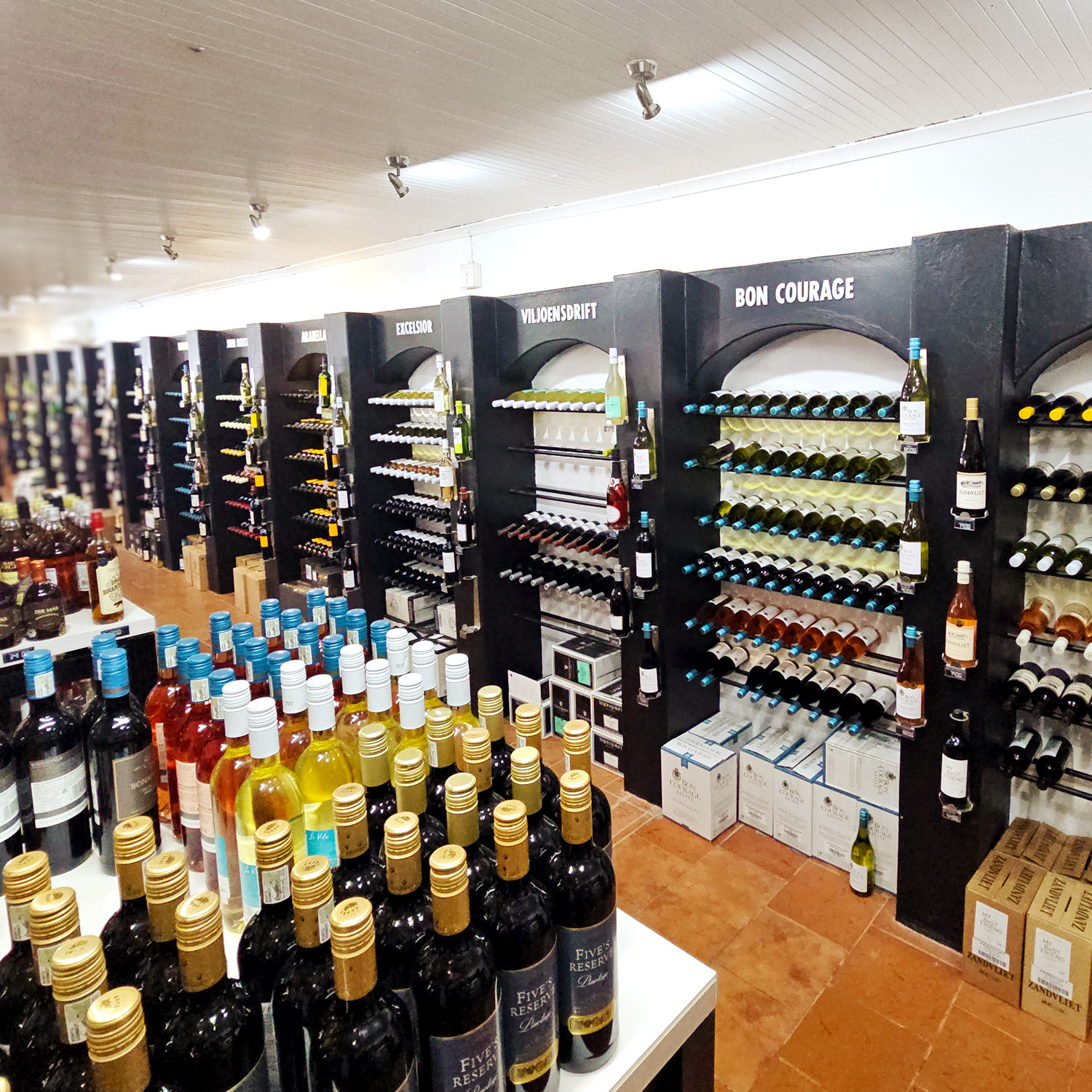 Interior of a wine boutique with shelves displaying a variety of wine bottles, including red, white, and rosé options. The space has a well-organized layout with labels visible.